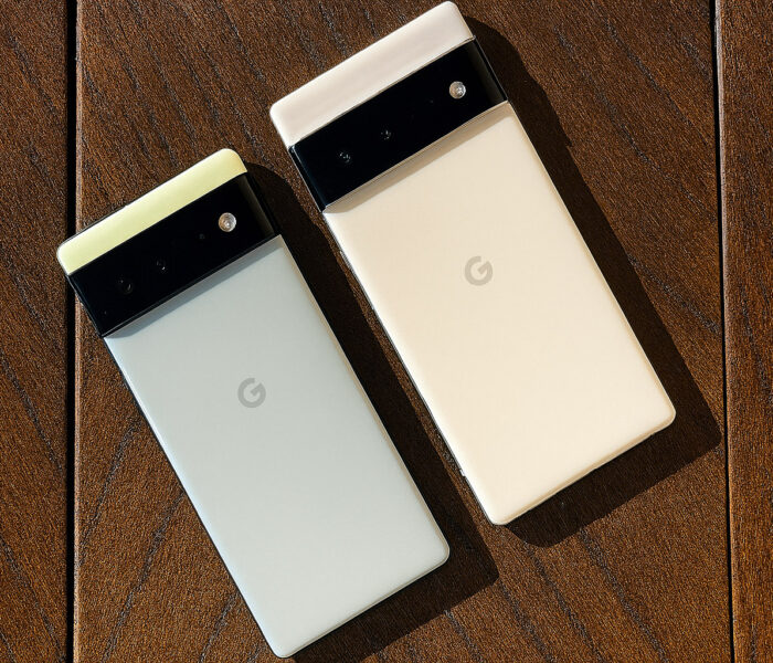 Dva Android telefona na temno rjavi hrastovi mizi, prikaz pregrevanja android naprav v vročem okolju.